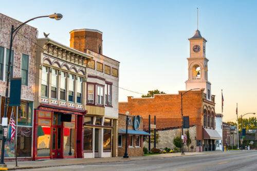 A small town street with storefronts that are a part of a chamber of commerce.