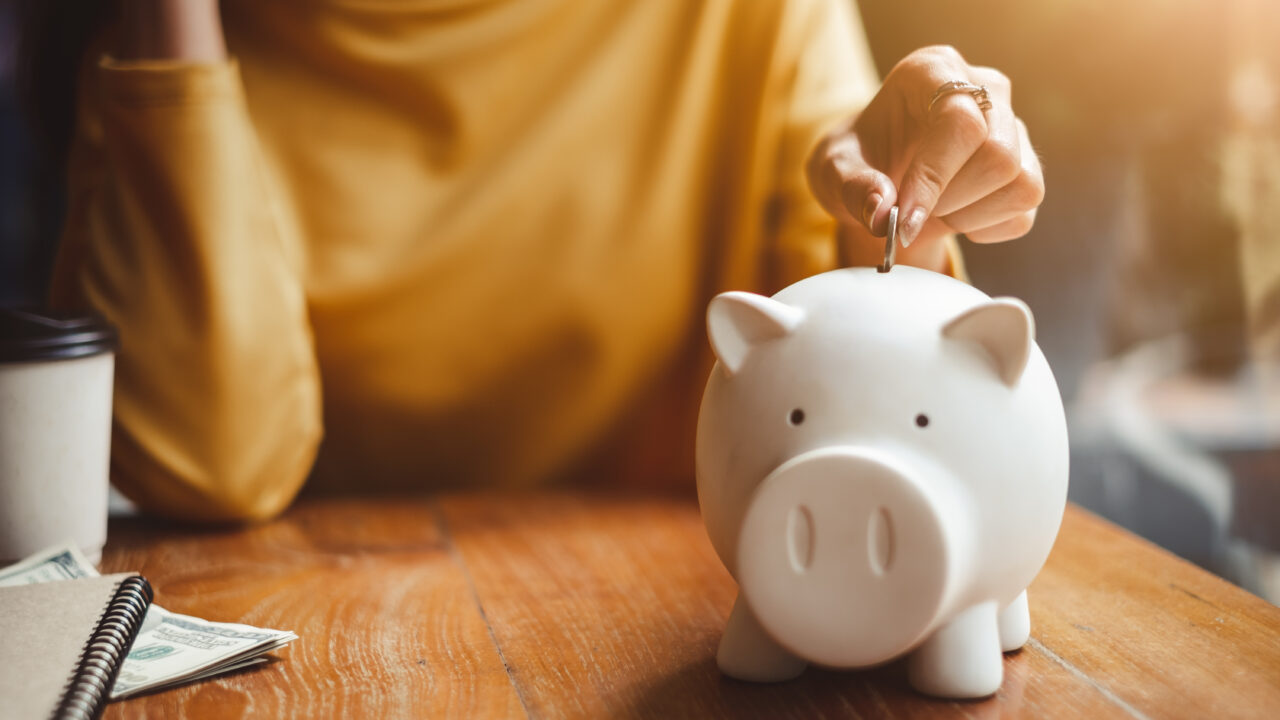 A person accumulating non-dues revenue and storing that money in a piggy bank.