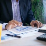 
                            A professional uses a tablet at an office desk to track and manage membership dues.                            