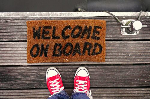 A pair of shoes on a welcome mat, welcoming a member who has completed an association membership form.