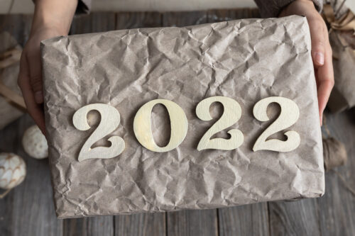 wrapped gift with 2022 on the top of it held by hands