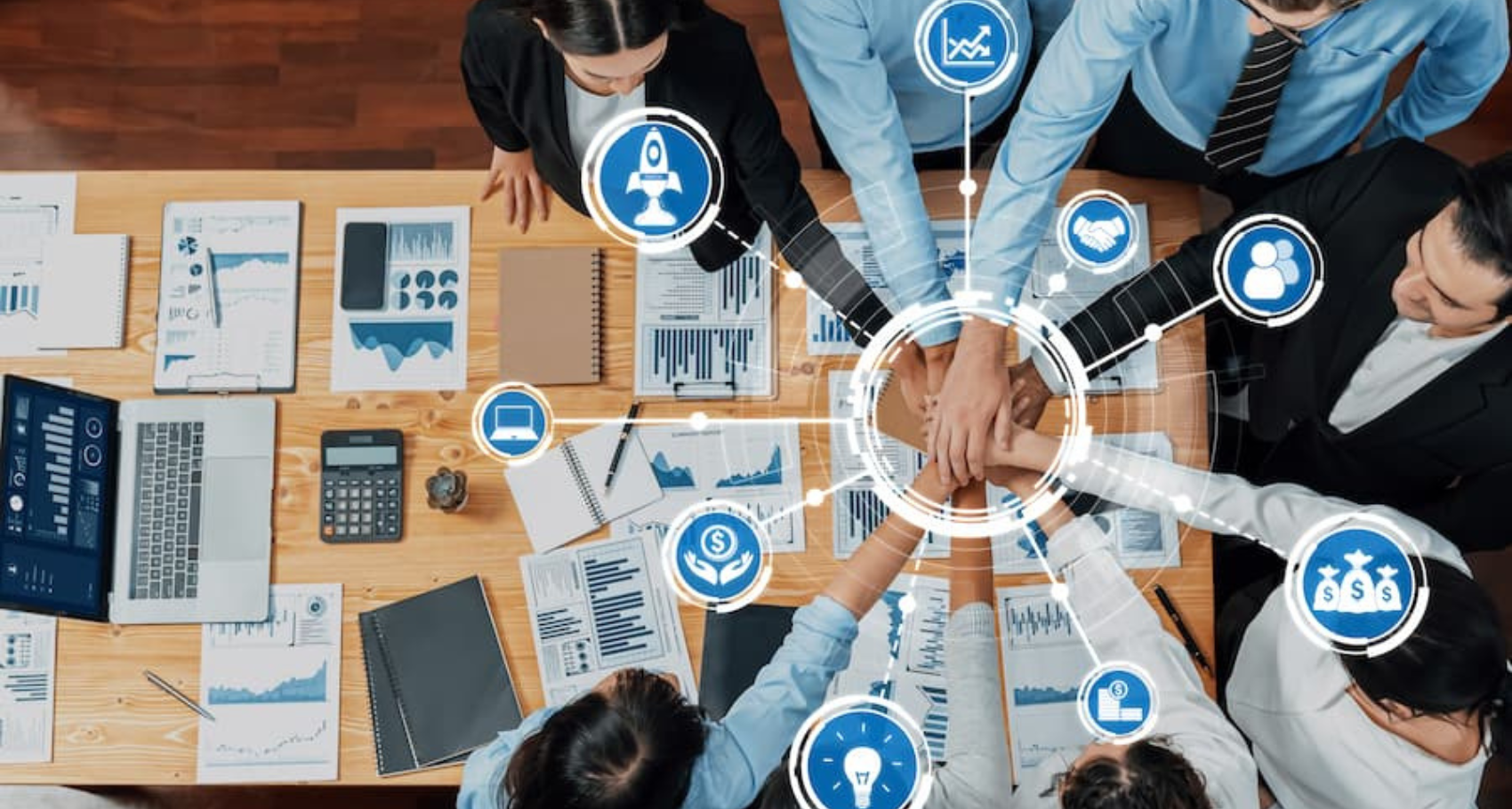 Aerial view of diverse team members engaged in a collaborative business meeting, showcasing active discussion, strategic planning, and data analysis for project success.
