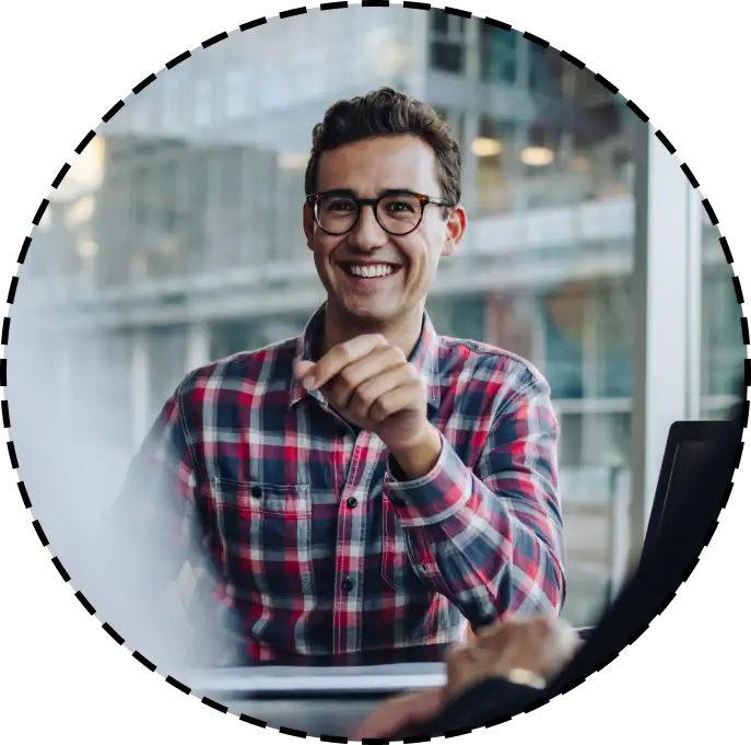 man smiling next to a large office window