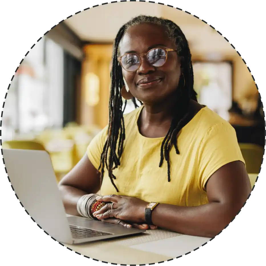woman smiling proudly beside laptop